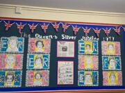 Wall display showing portraits of the Queen in the style of commemorative stamps.